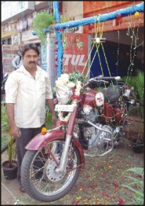 Inayath Ulla Shariff poses alongside his 200 kg Royal Enfield bike, hung from a boiled egg, at his garage 'Track Point' on Sawday Road in city. [Pic. by Golden Babu]