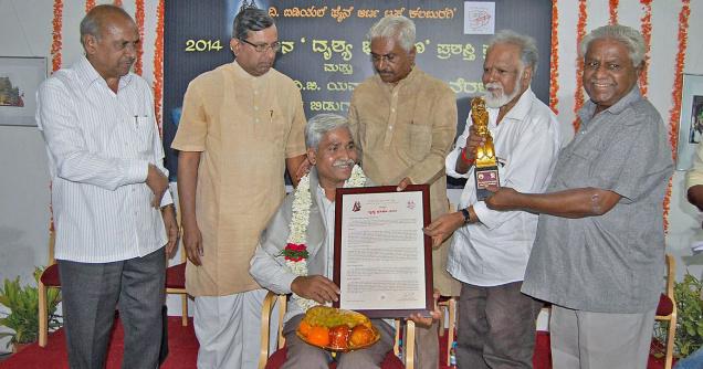Artist Basavaraj S. Musavalagi being presented the Dhrushya Bhushana Award in Kalaburagi on Friday. —Photo: Arun Kulkarni 