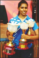 Spoorthi posing with trophies. 