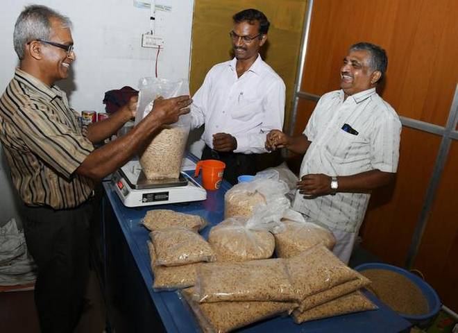 Members of Savaya Krushika Grahaka Balaga re-packing organic rice purchased from farmers in north Karnataka. | Photo Credit: H_S_Manjunath