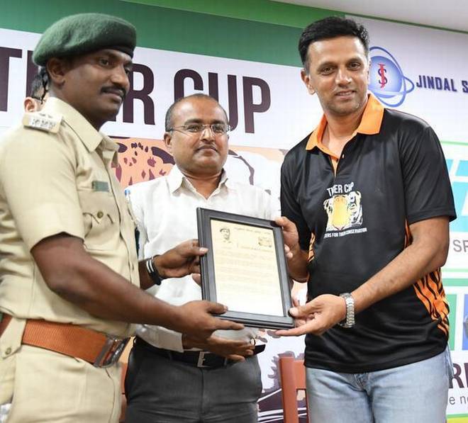 Cricketer Rahul Dravid presenting the Wildlife Service Award 2018 to Forest Guard J. Yogaraja of Lakavalli range in Bhadra Tiger Reserve. In the middle is Forest Officer Manoj.   | Photo Credit: G_P_Sampath Kumar