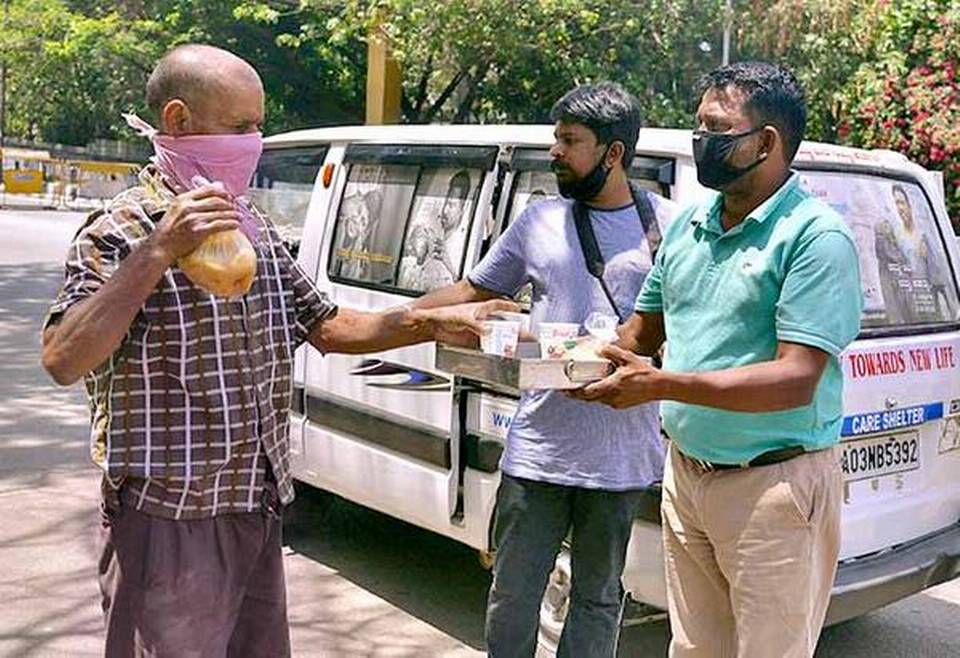 Helping hand: Members of an NGO distributing food in Bengaluru on Friday. | Photo Credit: V. Sreenivasa Murthy