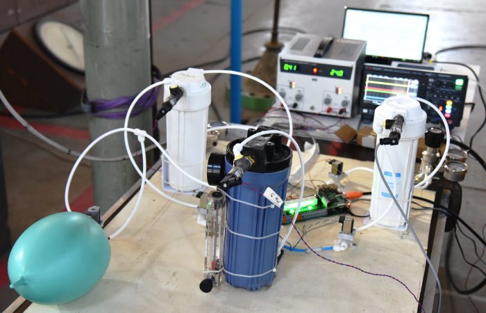 A benchtop test setup of a ventilator prototype being built by IISc scientists and volunteers at IISc’s High-Speed Wind Tunnel Complex.The prototype is created out of components from the Indian automotive and RO filter industry. The white canisters contain air and o2, which are mixed in the blue cylinder. The control circuitry is composed of PCL board and Raspberry Pi. The medical test lung is for experimentation testing only. (Photo courtesy IISc Project Praana Team) 