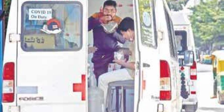 Ambulance staffers on Covid-19 duty grab a bite as they wait near a testing centre on JC Road, Bengaluru, on Tuesday | Nagaraja Gadekal